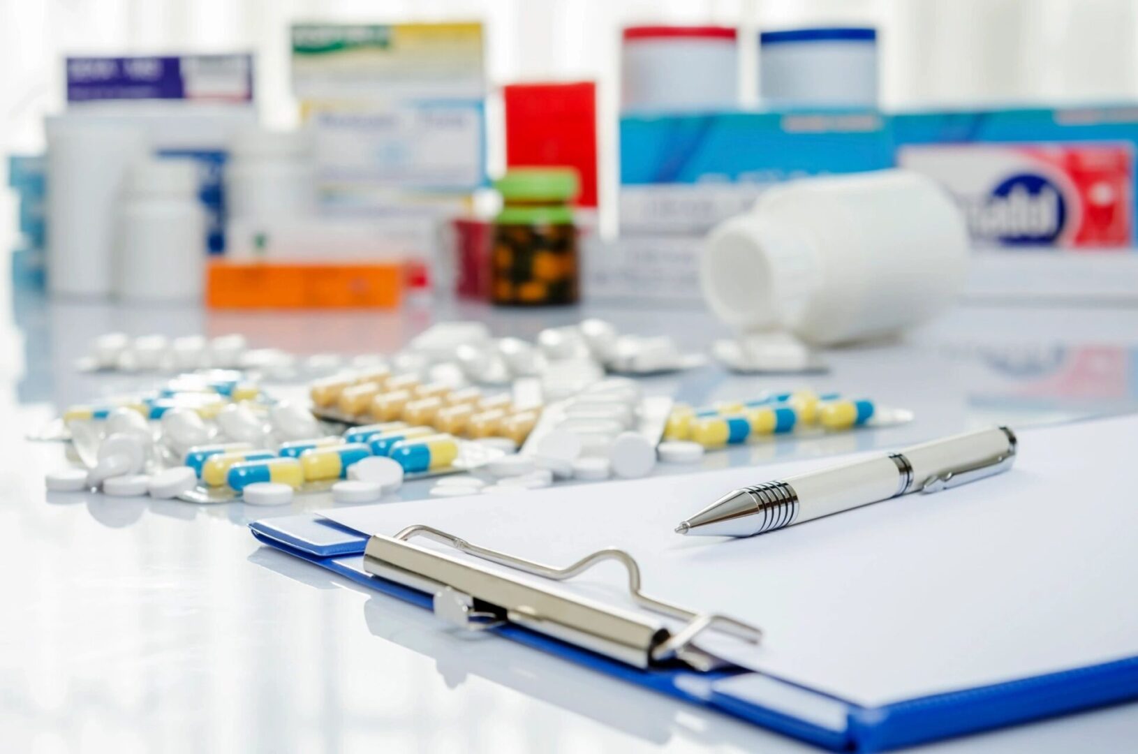 Medical clipboard with scattered pills and medicine bottles in the background.
